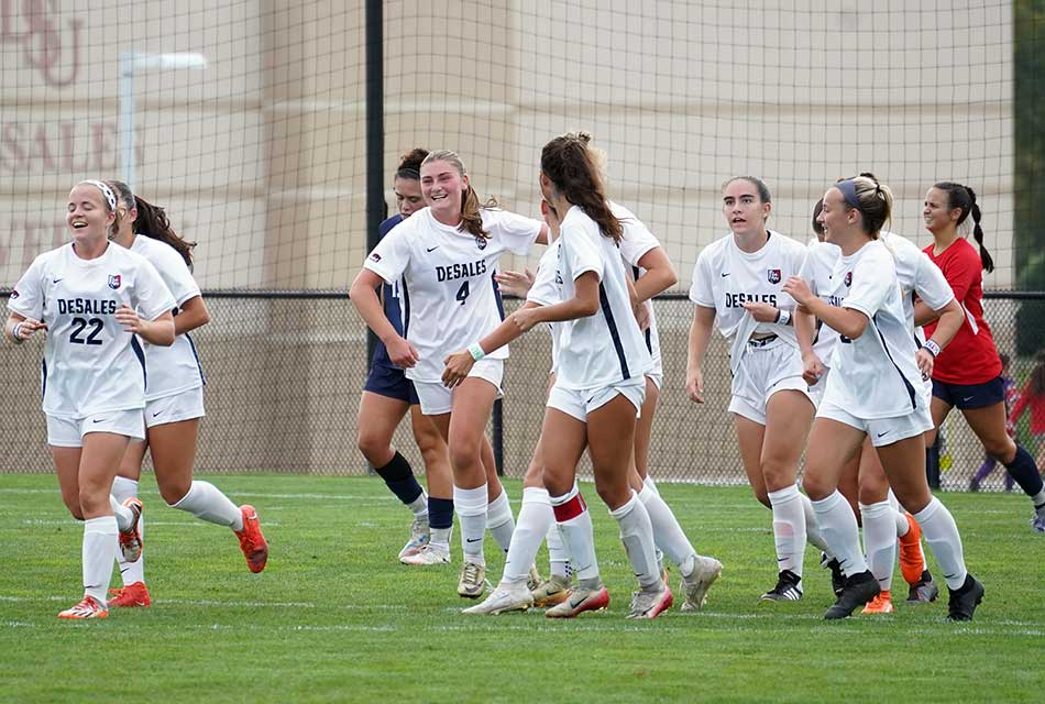 womens soccer team celebrating after a goal