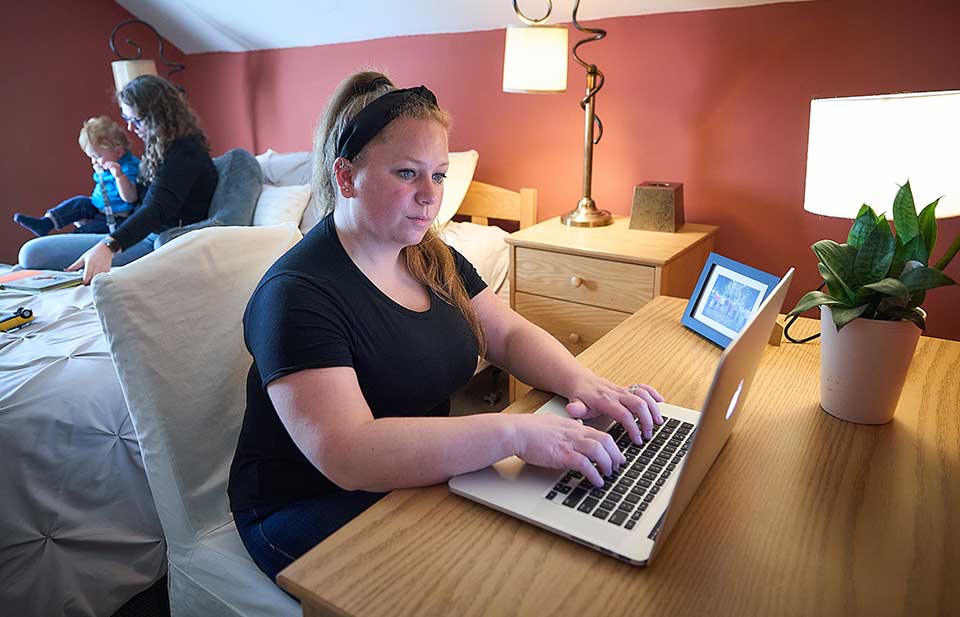 female student doing classwork on laptop at home