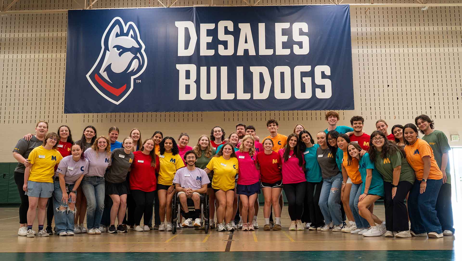 students under a bulldogs banner in the gym