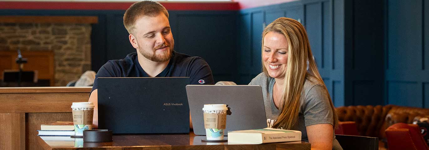 students in cafe with laptops