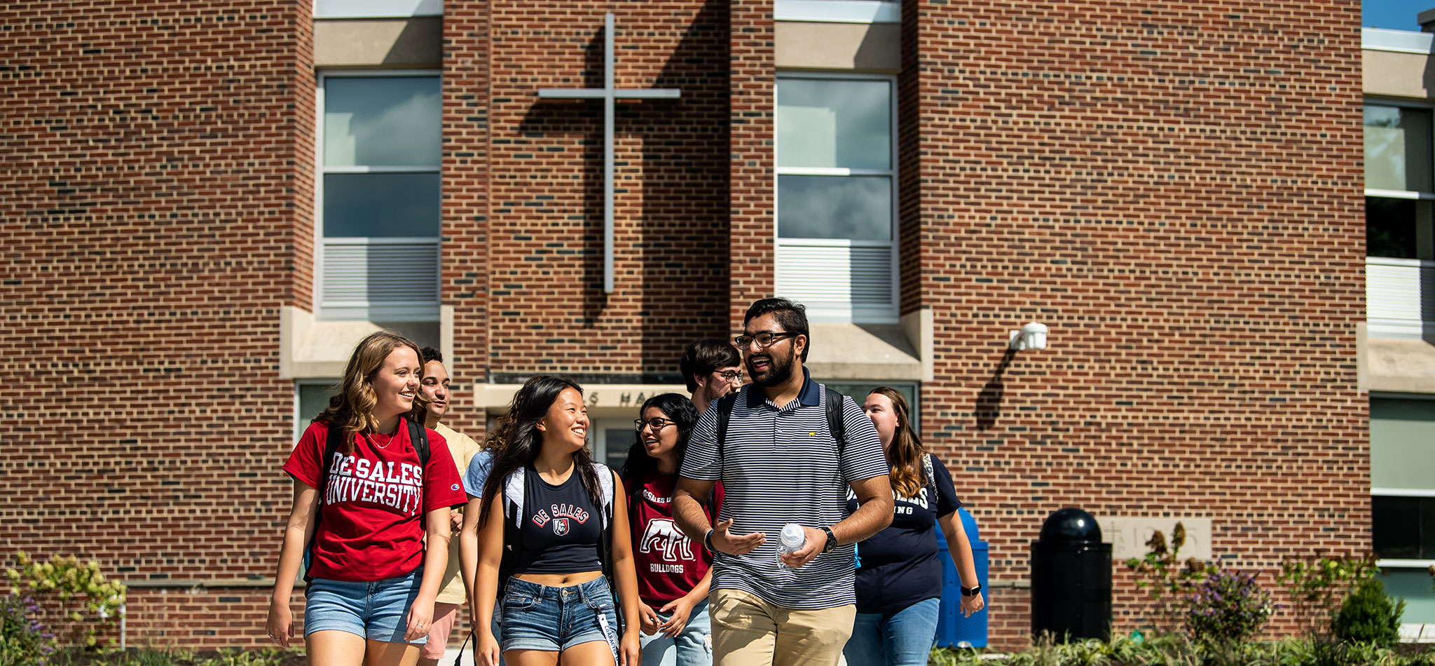 A group of DeSales University students walking, smiling and laughing.