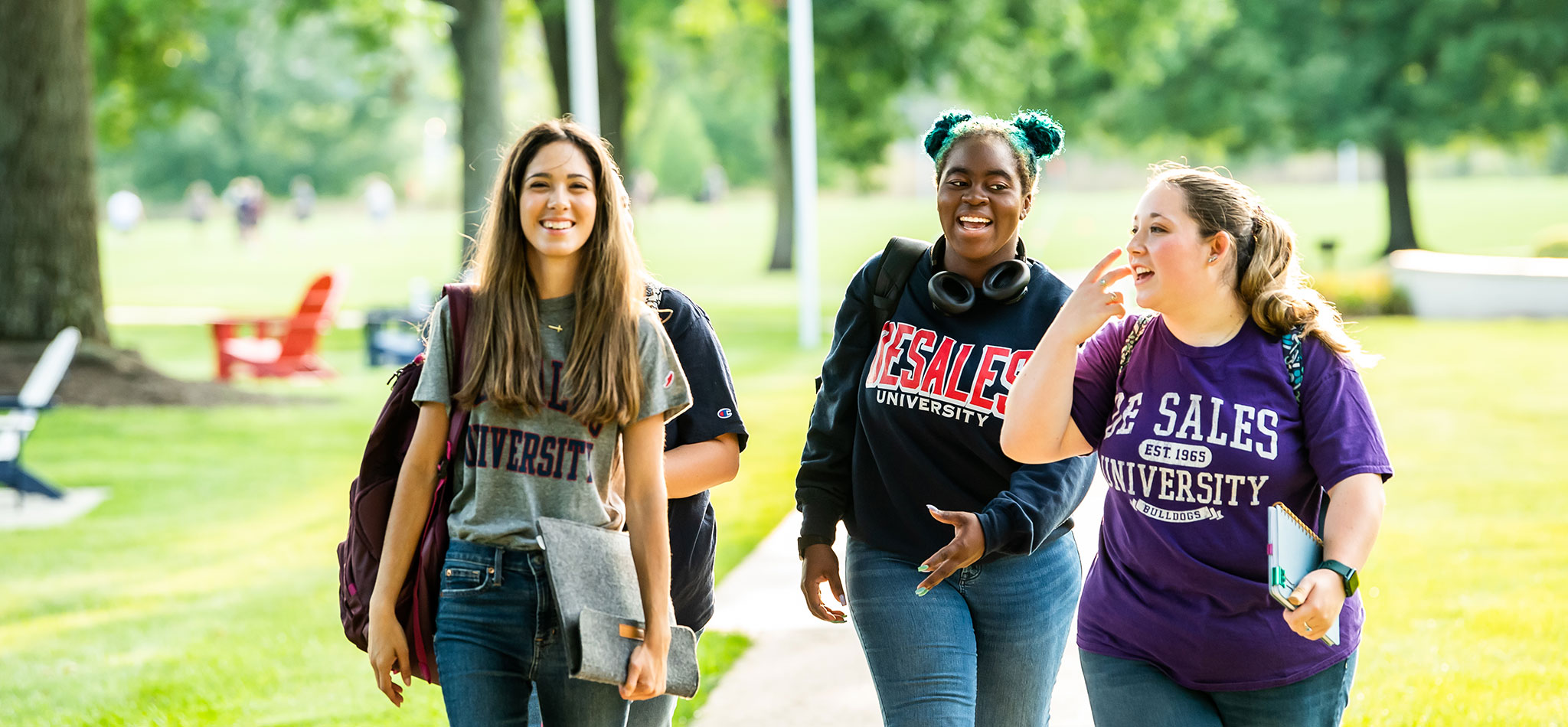 A group of DeSales University students walking, laughing and smiling.
