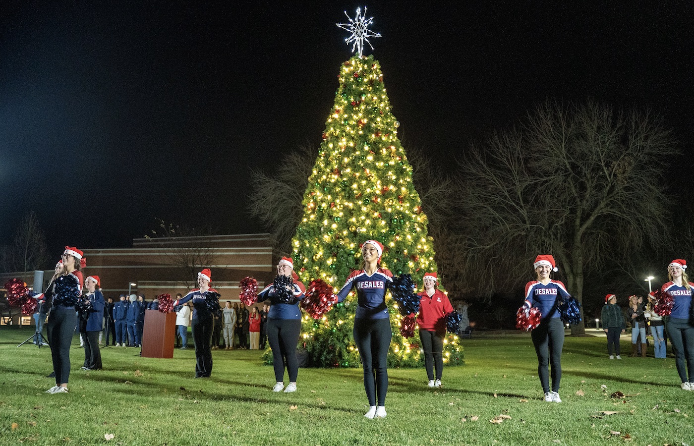 DeSales Cheer Team performing in front of Christmas tree on campus mall