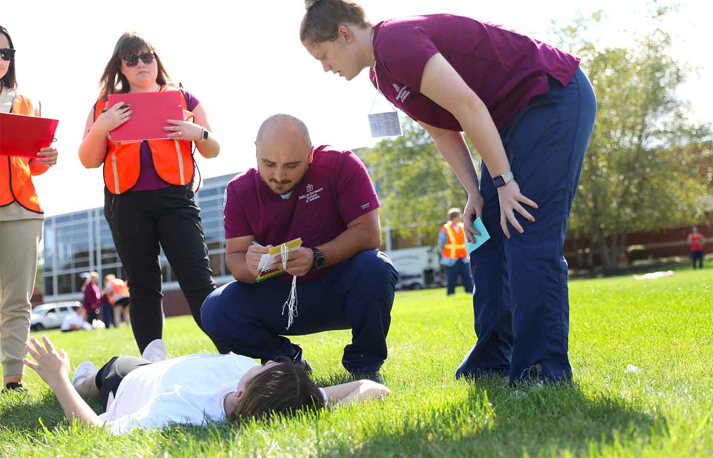 Cameron Kieffer examining a patient during nursing, homeland security disaster simulation outside the DUC