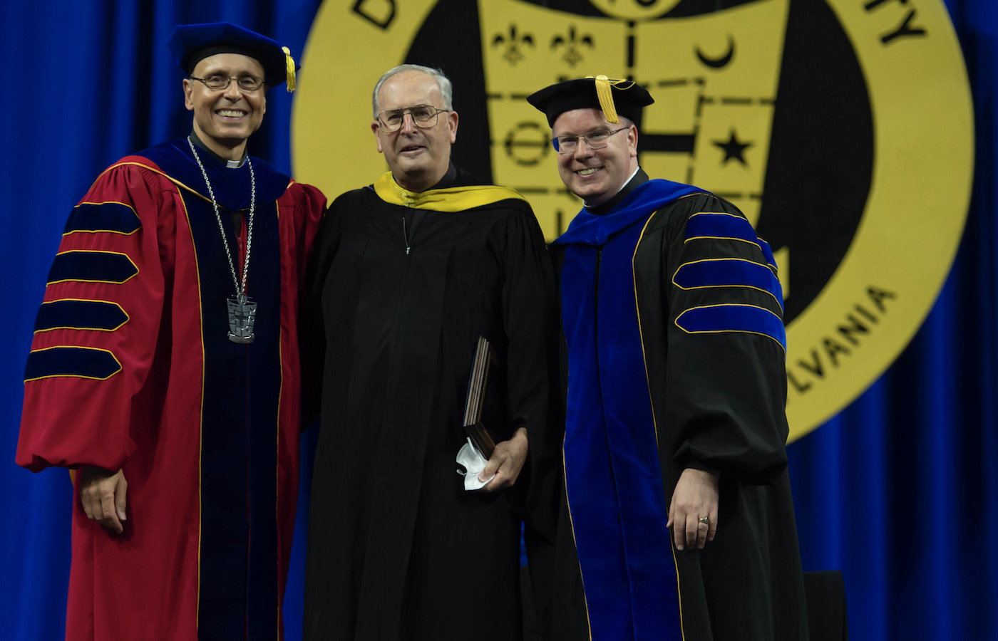 Father James Greenfield, Father Doug Burns, Brother Dan Wisniewski at Commencement 2022 after Fr. Burns received the Provost’s Faculty Excellence Award 