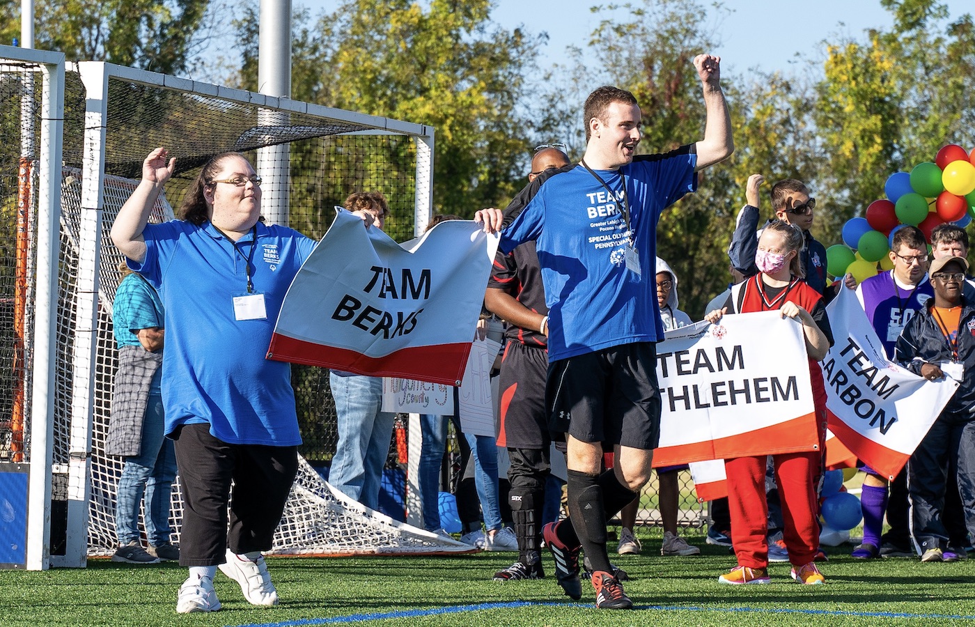 Special Olympics athletes carrying sign during Eastern Fall Sectional