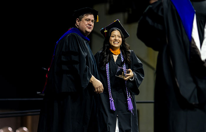 Luz Pomaquiza receiving Provincial Medal of Honor from Very Reverend Jack Kolodziej during commencement ceremony.